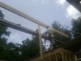 Carpenter setting a ridge beam over a new addition frame — Ice Dam Removal by Roofing Brothers in South Yarmouth