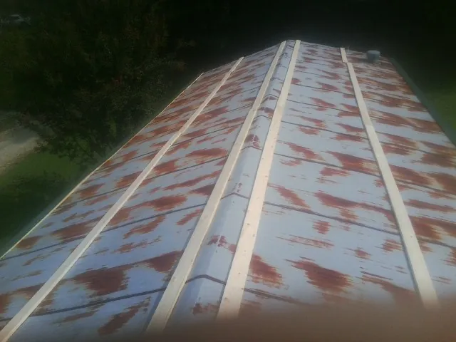 Rusted metal roof panels with new wood purlins before replacement — Storm Damage Roof Repair in South Yarmouth by Roofing Brothers