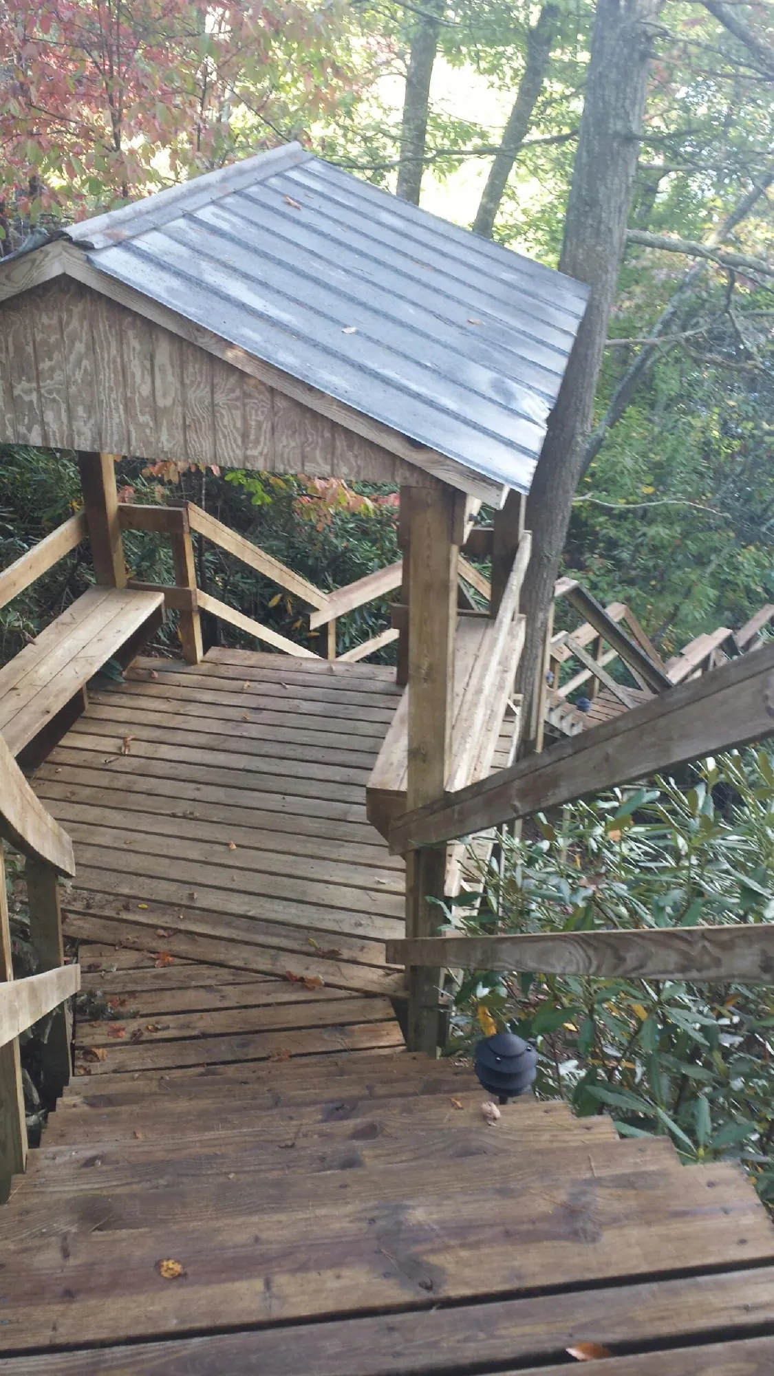 Metal roofed shelter over wooden steps on a wooded walkway — Skylight Repair & Installation work by our crew in South Yarmouth
