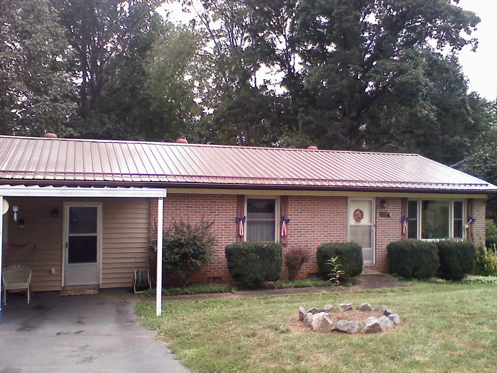 Bronze metal roof and carport on a brick ranch home — Roof Repair work by our crew in South Yarmouth